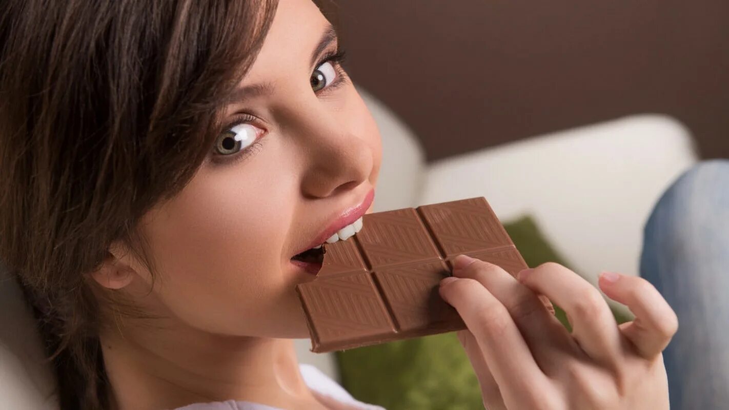 Девушка есть конфеты. Поедание шоколада. Девушка ест шоколад. Девушка ест шоколад. Красивая девушка с шоколадом.