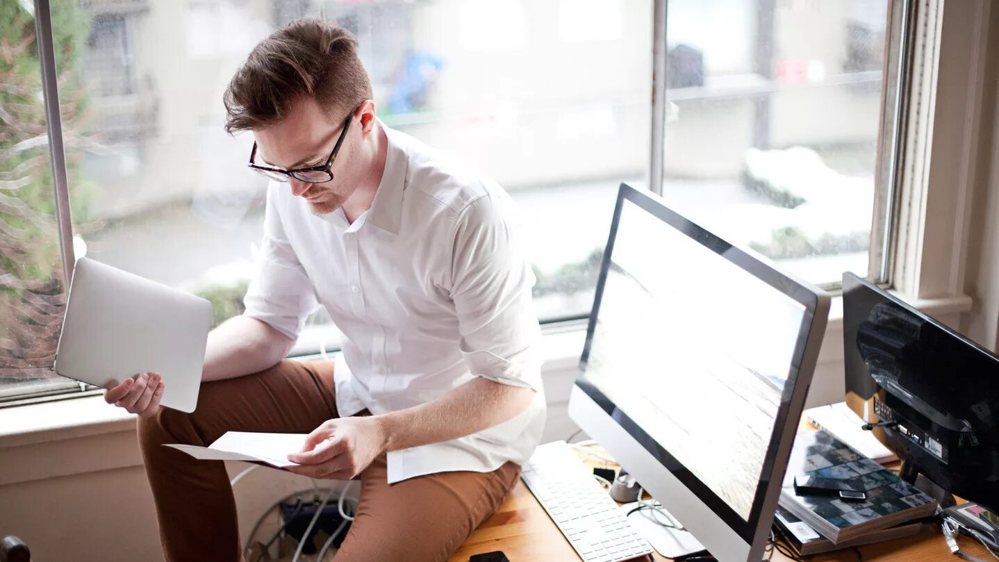 дизайнер мужчина. человек с ноутбуком в офисе. работа удаленно. копирайтер. мужчина в костюме показывает ноутбук стоковое фото.