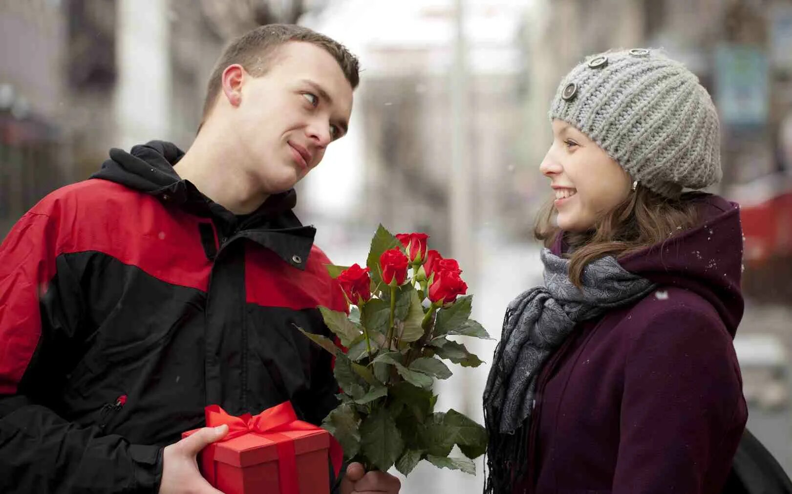 Молодой человек дарит цветы. Мужчина дарит цветы женщине. Парень дарит девушке цветы. Девушке дарят цветы. 8 января мужчина