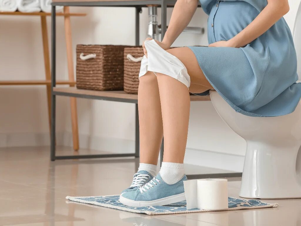 Женщина сидит на унитазе. Девушка с ногами на унитазе. Можно тужиться в туалете при беременности