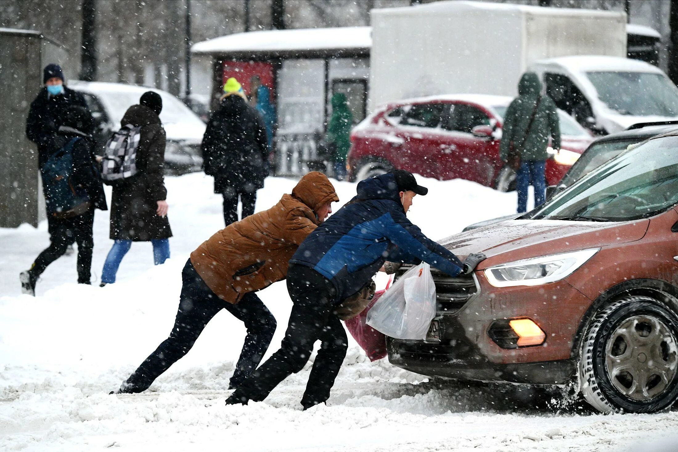 Сильный мороз в городе. Снегопад в городе. Толкают машину зимой. Сильный снегопад в Москве. Сильная метель в Москве.