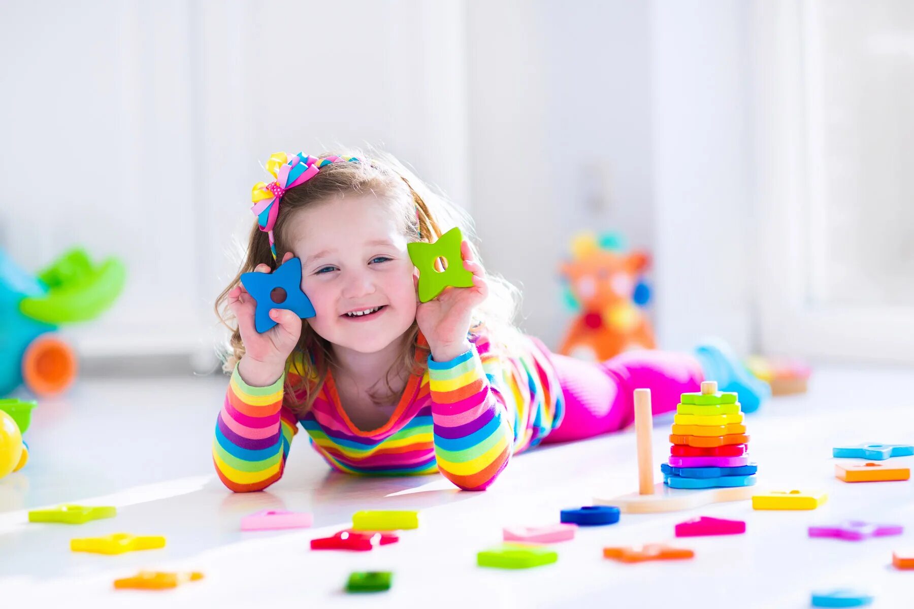 Девочка играет маленькими игрушками. Игрушки для детей. Радостные дети. Дети играются. Счастливые дети с игрушками.