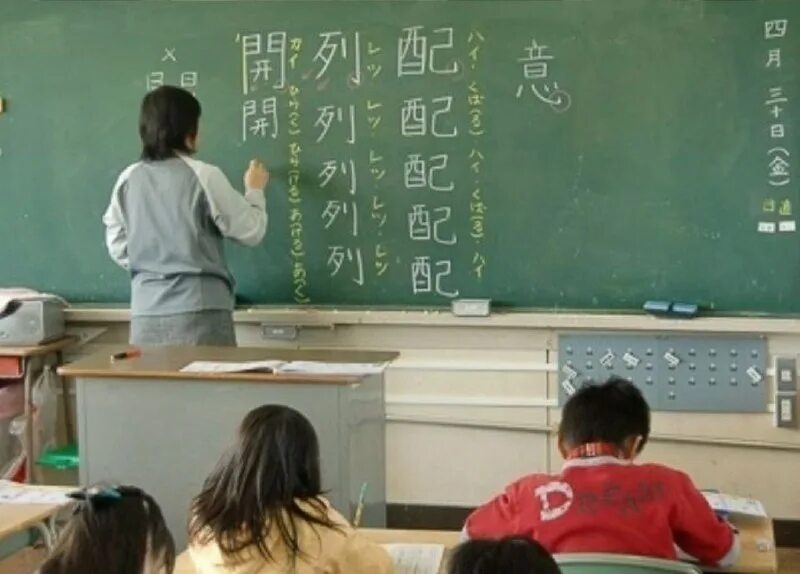 ученик у доски. ребенок у доски в школе. язык на уроке математики. счастливый ученик. язык на уроке математики.