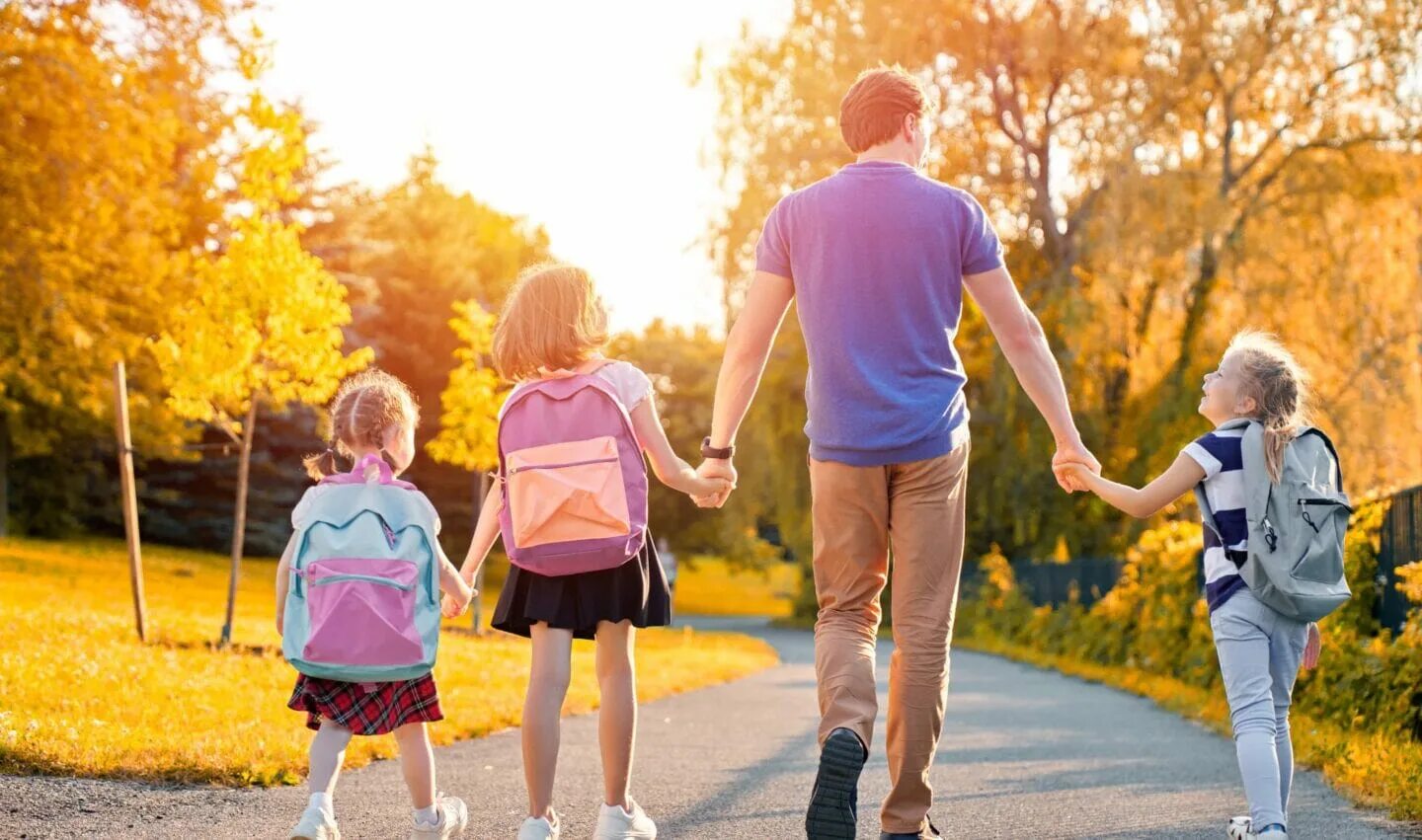 Родители с детьми в парке. Дети с родителями в парке. Семейная прогулка. Счастливая семья гуляет в парке. Родители с ребенком за руку.