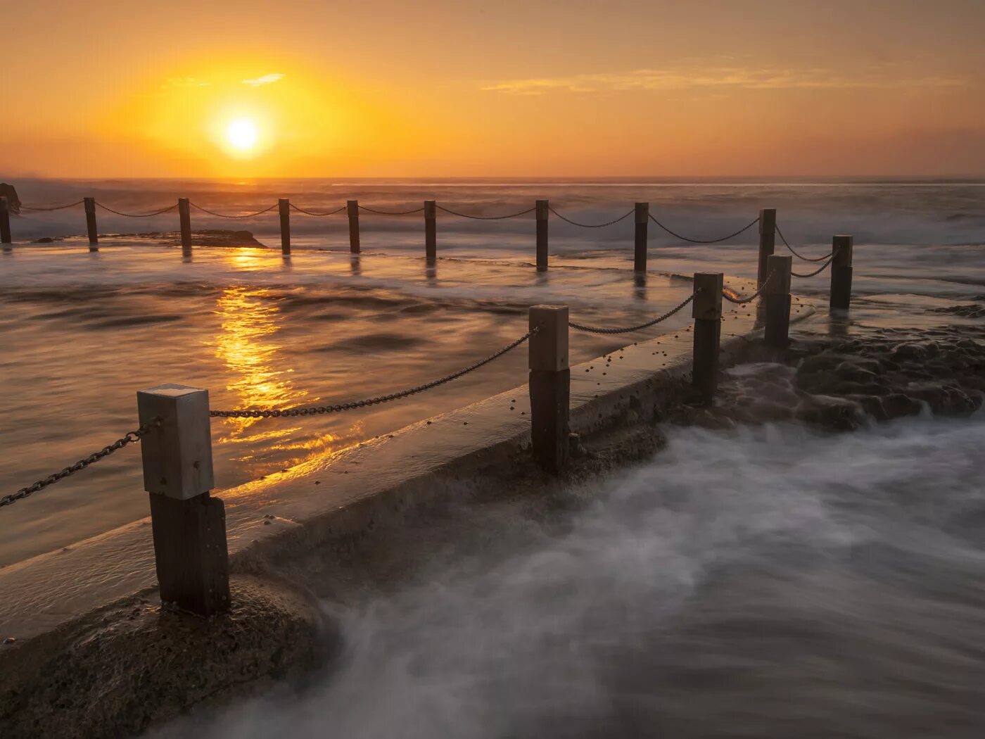 Волны на пирсе. Каменный пляж. Море пристань. Забор к морю. Каменный забор у моря.