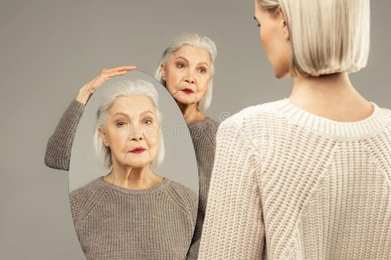 Старость в зеркале. Отражение пожилой женщины в зеркале. Отражение старухи в зеркале. Молодость в зеркале. Мы заметили молодую женщину