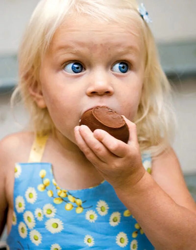 Маленький сладкоежка. Девочка ест шоколад. Девочка ест конфеты. Конфеты детям. Ребенок ест шоколад.