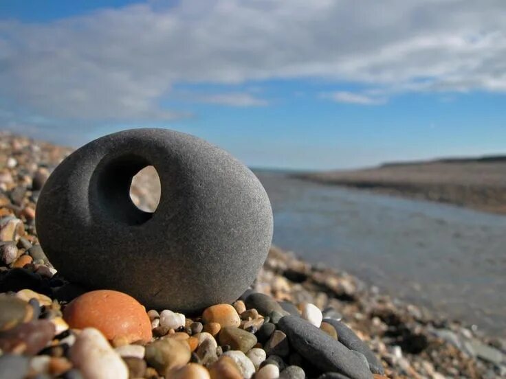 Круглое отверстие в камне. Примета найти камень с дыркой на море. Примета найти камень с дыркой на море. Куриный бог камень с дырочкой. Талисман куриный бог камень.