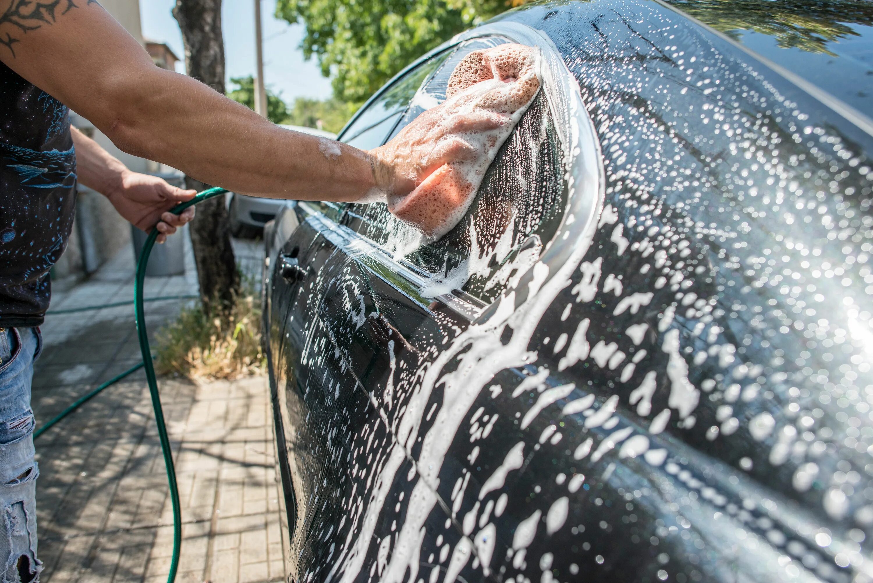 Можно мыть машину на своем участке. Моет машину. Машина на мойке крупным планом. Мытье машины в море. Man washing car.