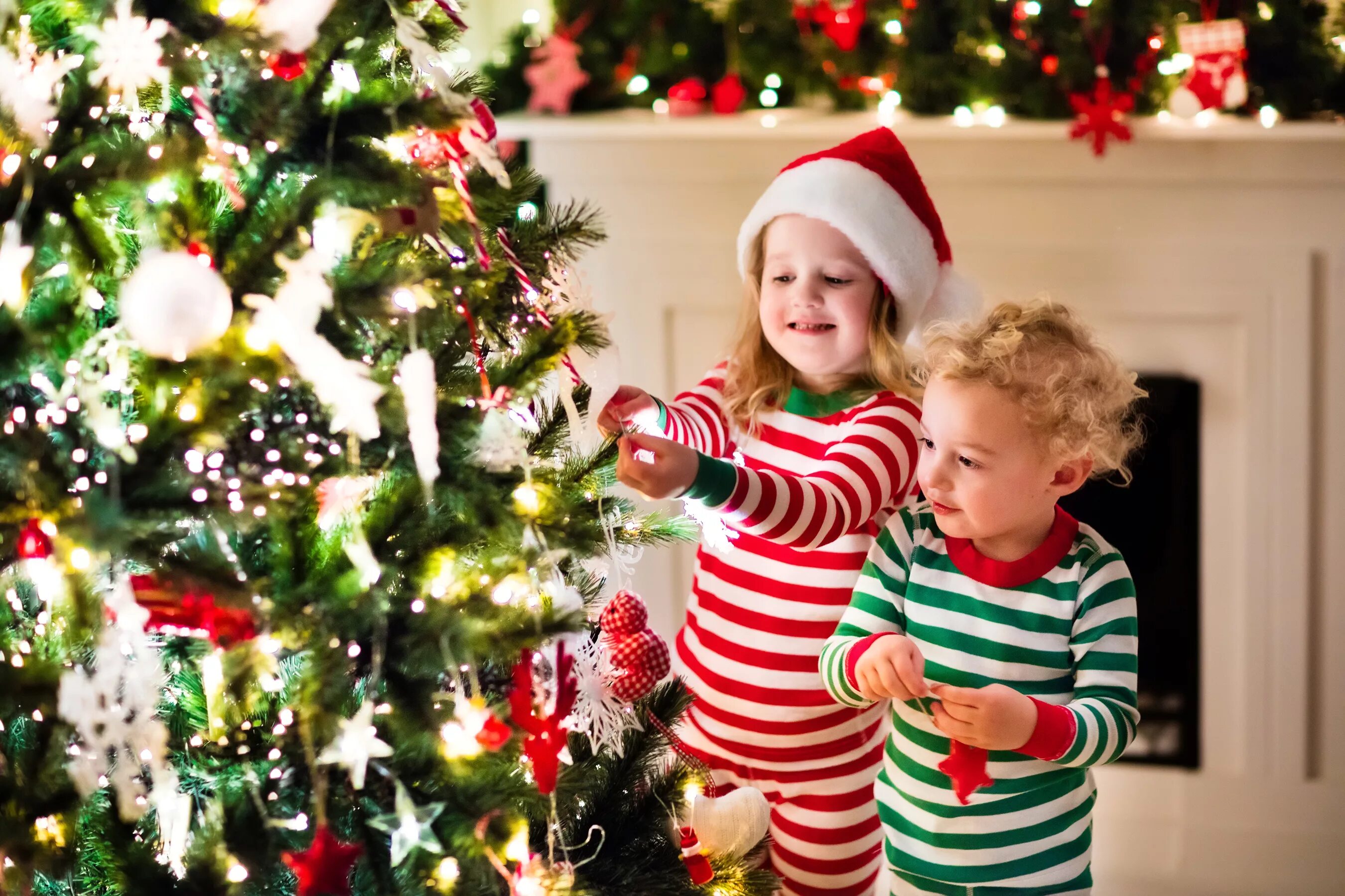 Новогодняя елка с маленькими детьми. Новый год дети. Дети наряжают елку. Елка для детей. Семья у елки.