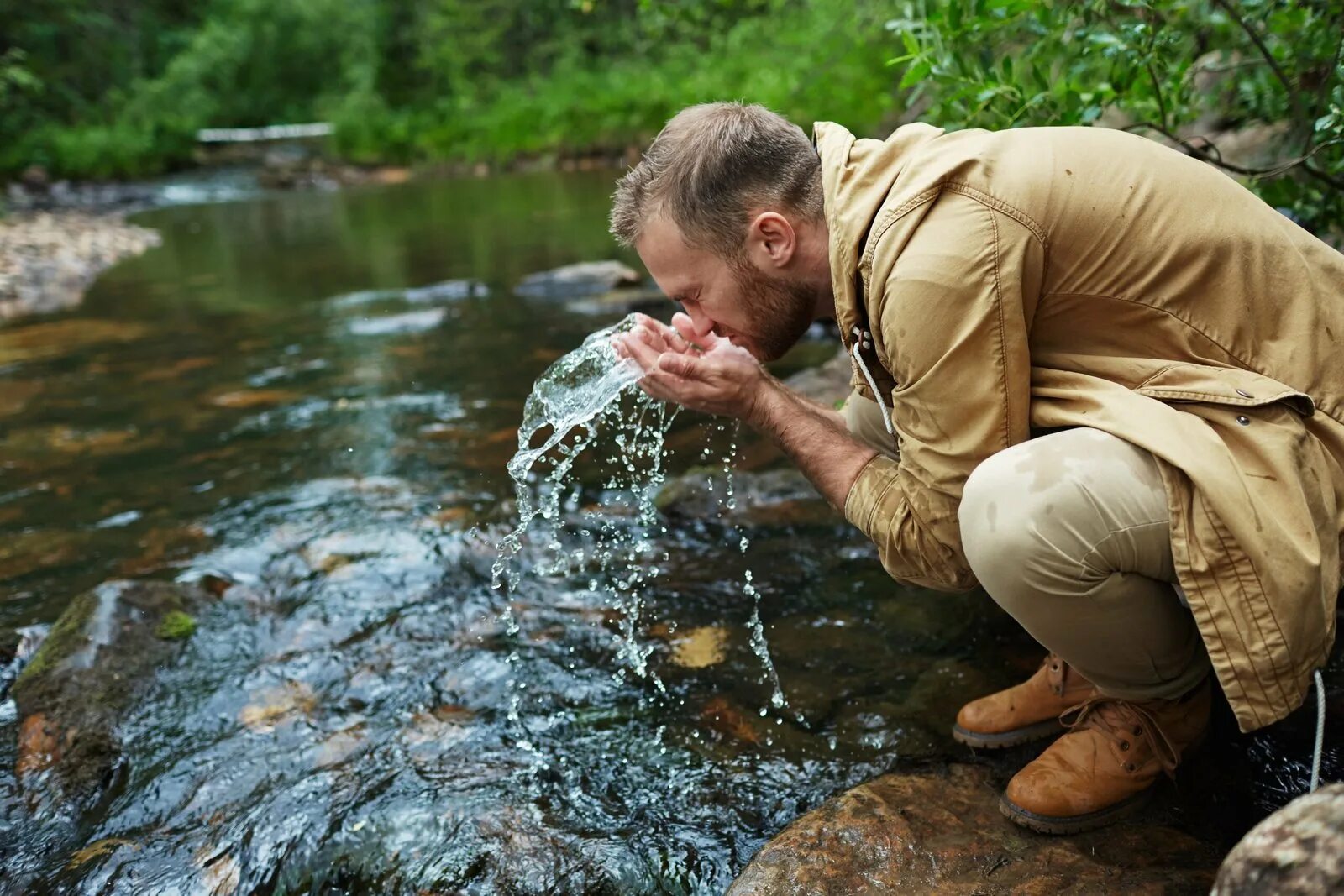 Выпив родниковой воды усталые путники. Человек около родника. Человек пьет воду из реки. Человек пьет воду из ручья. Пьет из реки.