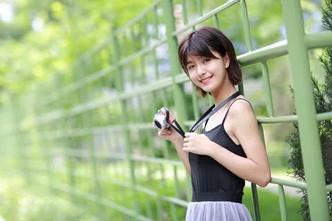 Wallpaper Young smiling asian with a camera at the fence.