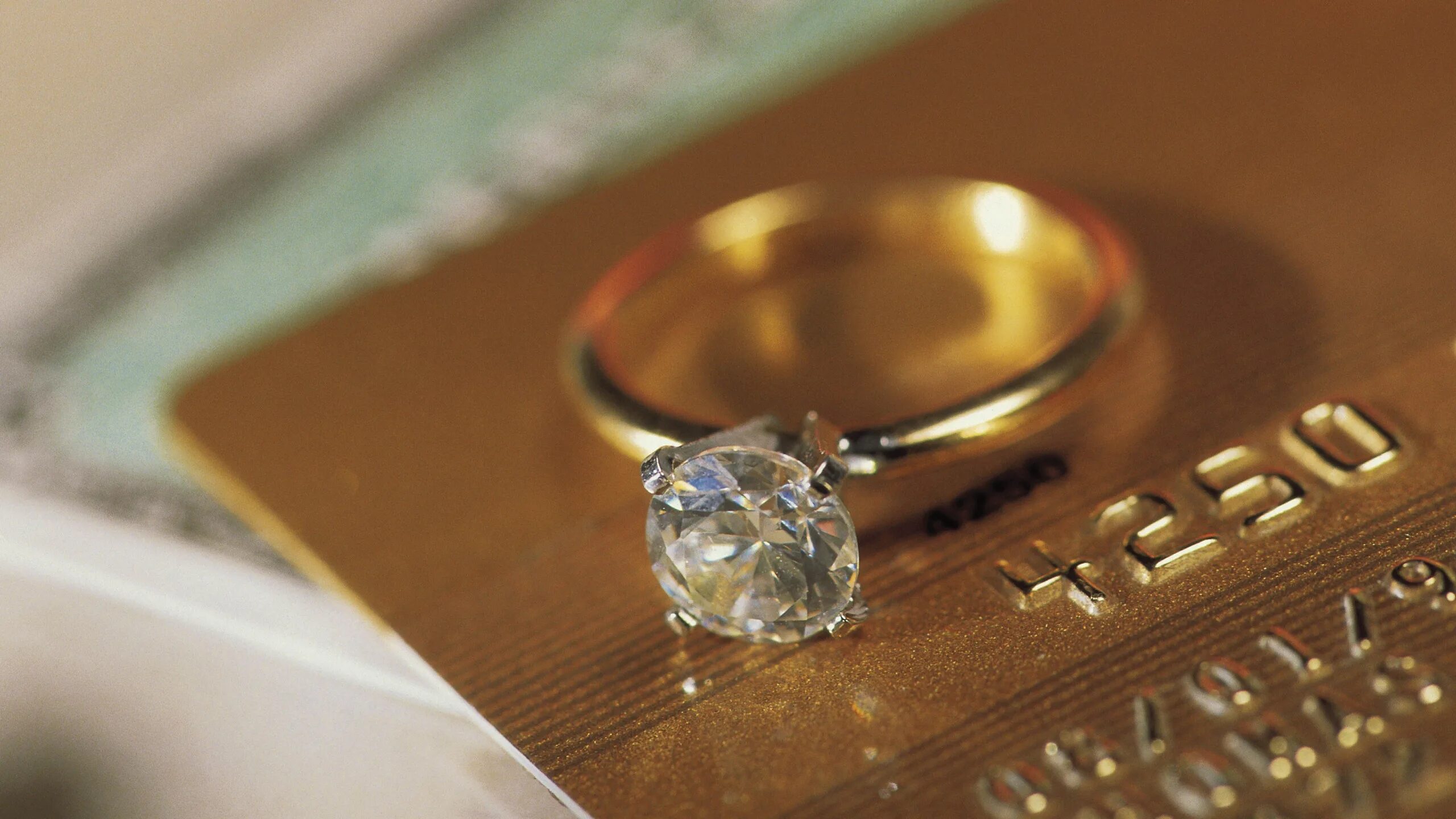 Ювелирные украшения на столе. Золото и бриллианты. Свадебные кольца. Богатство бриллианты. Алмазы богатство