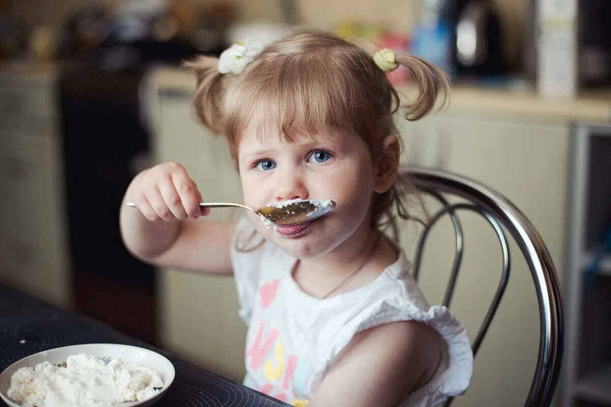 Детскую вкусную. Девочка кушает. Ребенок ест кашу. Ребенок завтракает. Девочка ест кашу.