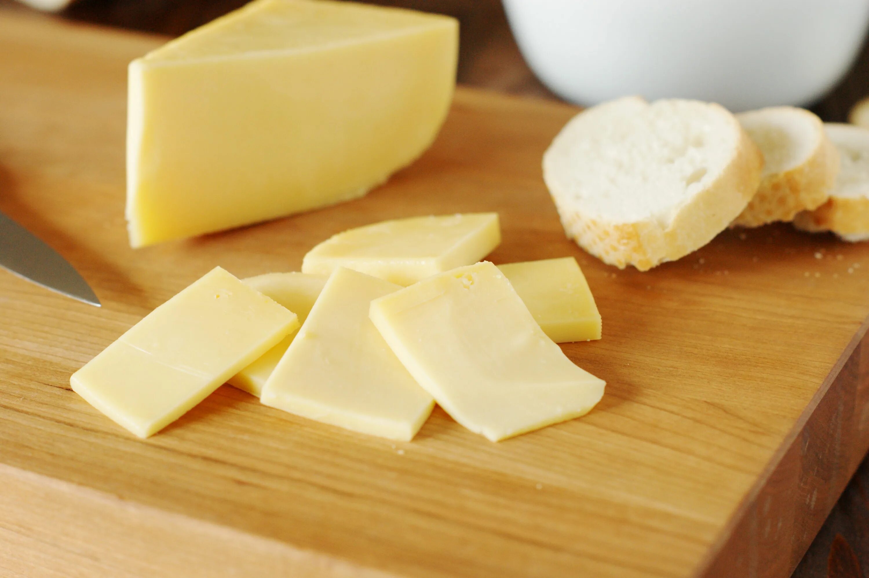 Premium Photo An elevated view of fresh gouda cheese slices on wooden desk Gouda