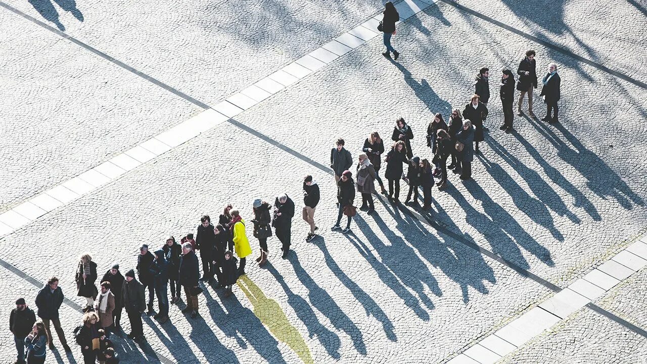 Первую очередь видим в. Толпа вид сверху. Огромная очередь. Очередь из мужчин. Тени людей на флаге Украины.