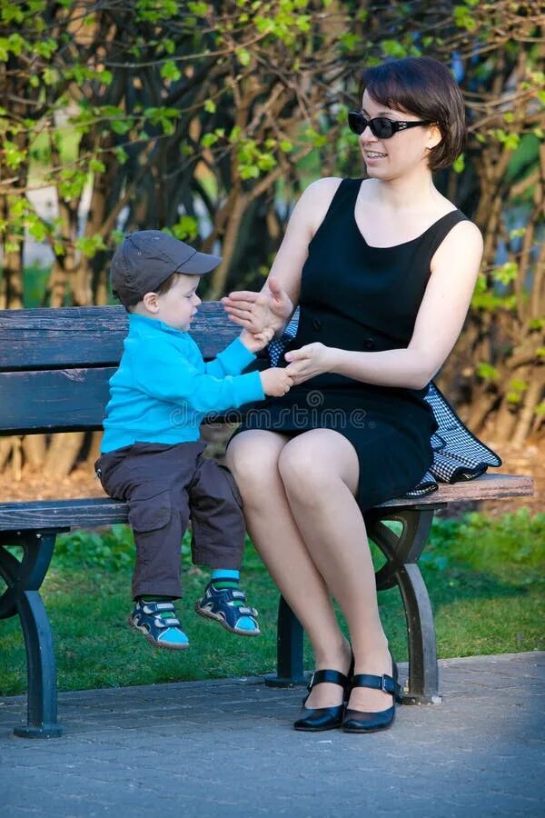 Мама сидит на сыне. Женщина сидит на маленьком мальчике. Мать сидит на сыне. Mother sitting on son.
