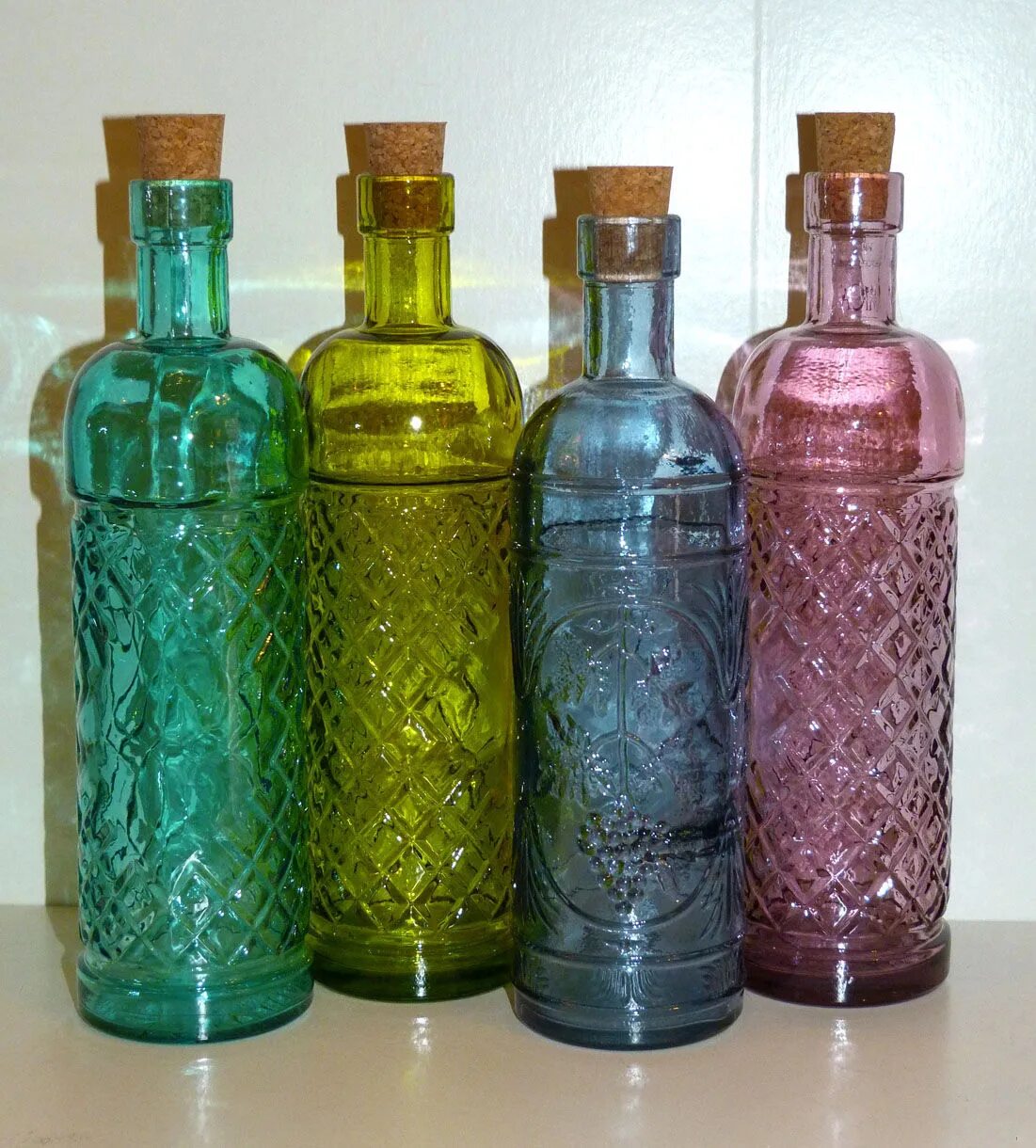 Цветные бутылочки. Цветные бутылки. Бутылка из цветного стекла. Разноцветные стеклянные бутылки. Стеклянная бутылка из цветного стекла.
