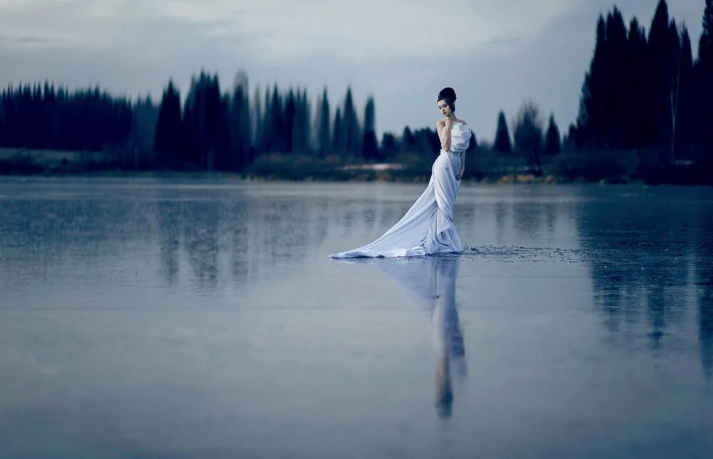 счастливая женщина на море. девушка стоит в воде. идущая по воде к солнцу. девушка идет вперед. женщина идет по воде.