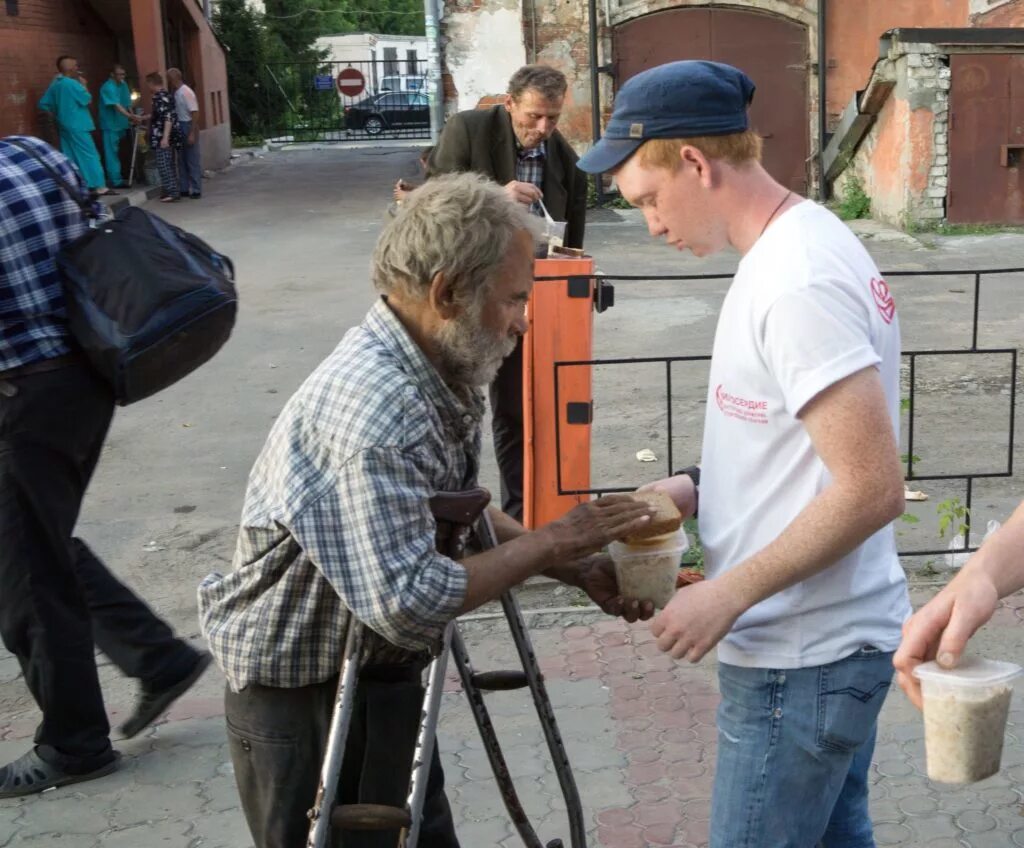 Банк помогает людям. Волонтеры помогают бездомным. Человек помогает бездомному. Помощь бездомным людям. Помогать бедным.