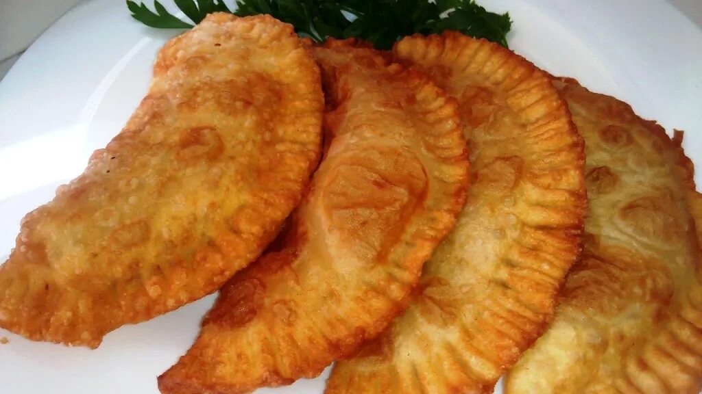 Как правильно есть чебуреки. Горячие чебуреки. чебуреки с мясом жареные. чебуреки на сковороде. много чебуреков.