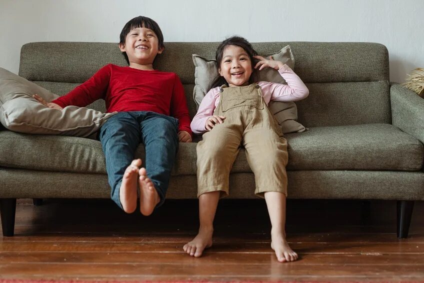 Kids are sitting on Sofa. Children sitting on the Couch. Laughing child on the Sofa. Sofa for children.