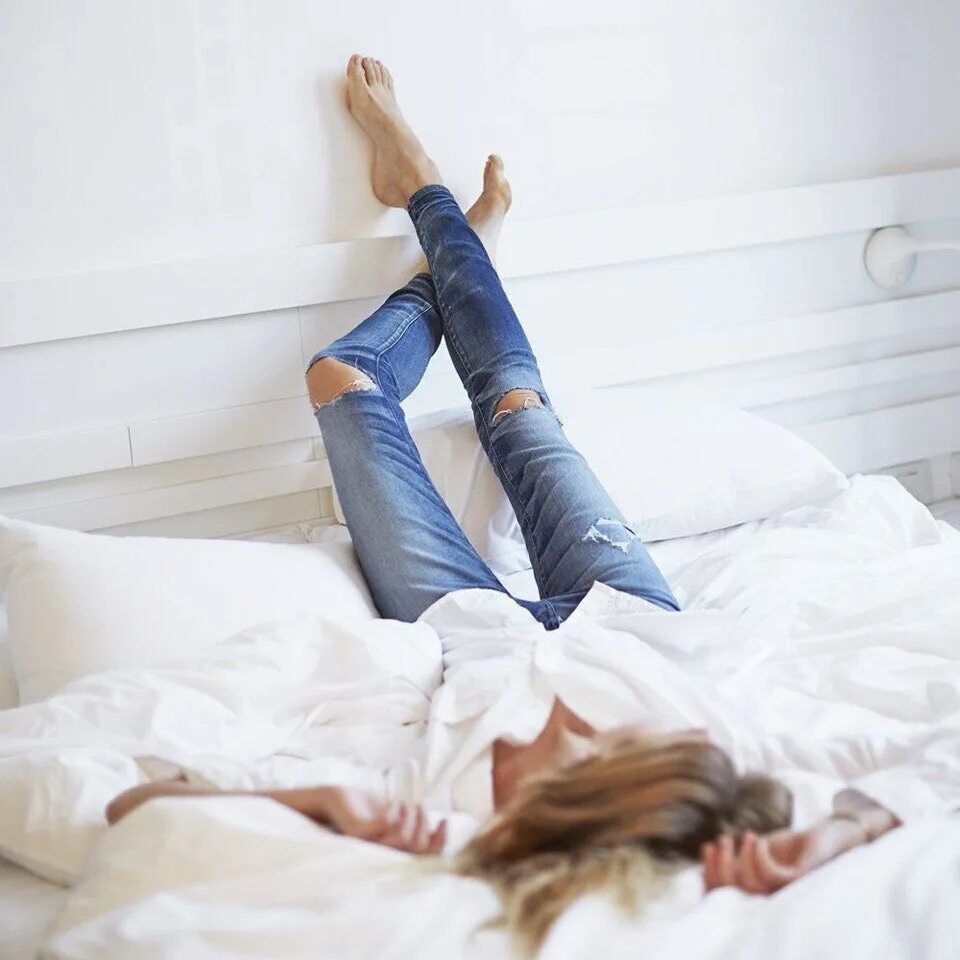 Картинка лежу на кровати. Девушка лежит. Фотосессия лежа. Джинсы на кровати. Девушки в джинсах лежат.
