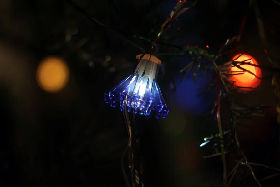 синий елочный шар на ветке. елочные шары на ветке. украшенная елка в лесу. ветки елки фон. елка с игрушками.