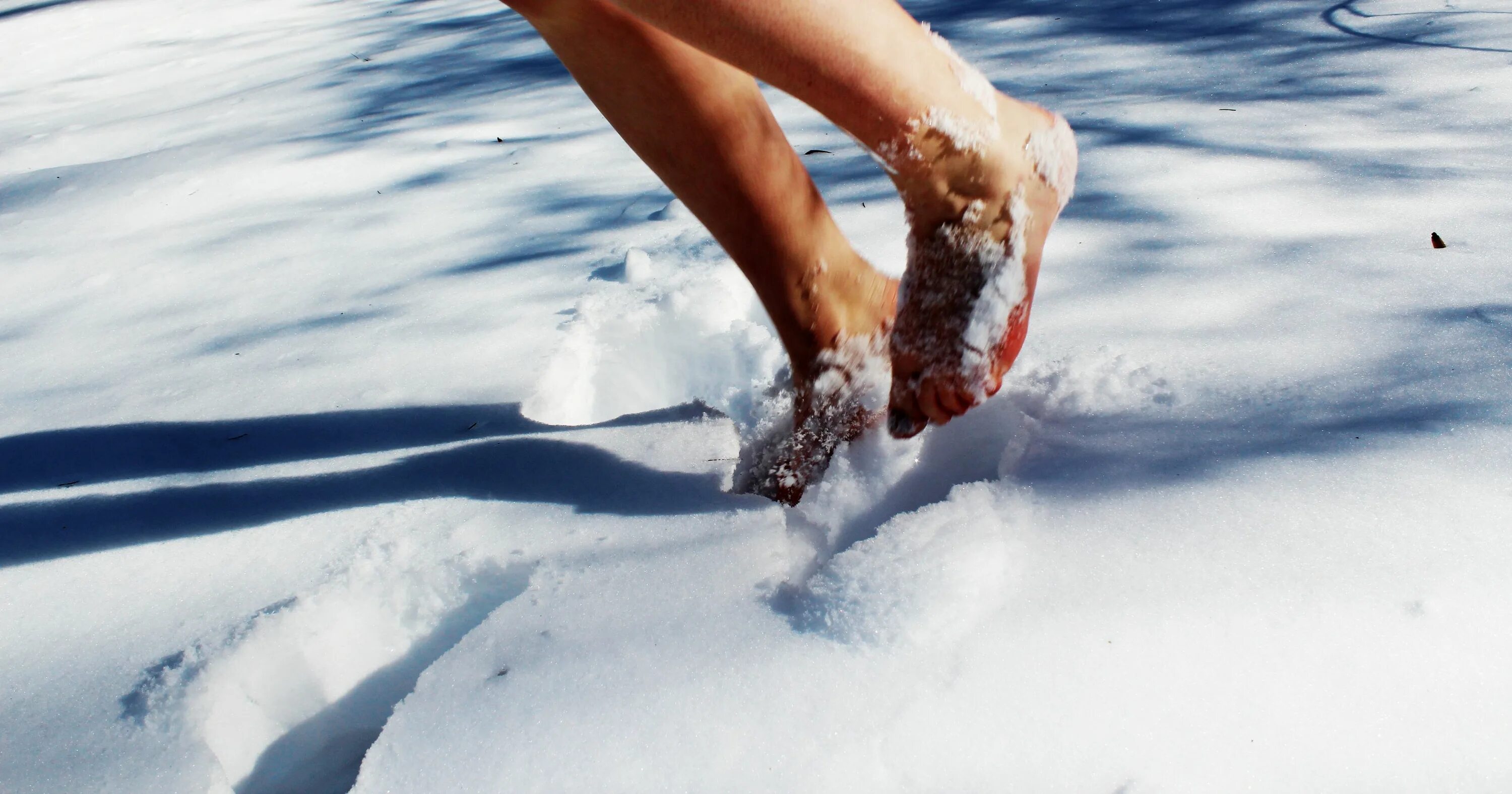 Все взморье утопает в свежем снегу. Босые ноги на снегу. Ступни на снегу. Закаливание снегом. Ходьба по снегу.