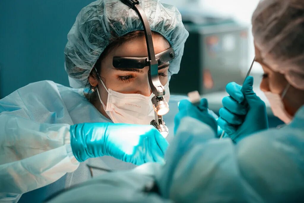 Хирургические операции на сердце. Пластическая хирургия. Хирургическая пластика лица. Женщина хирург в перчатках. Врач делающий пластическую операцию.