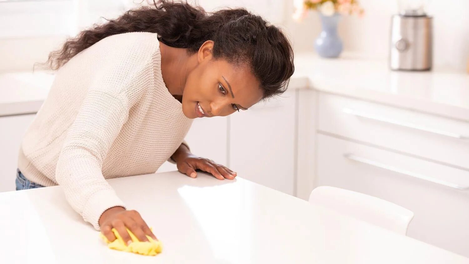 Do the dusting. Lean over the table.
