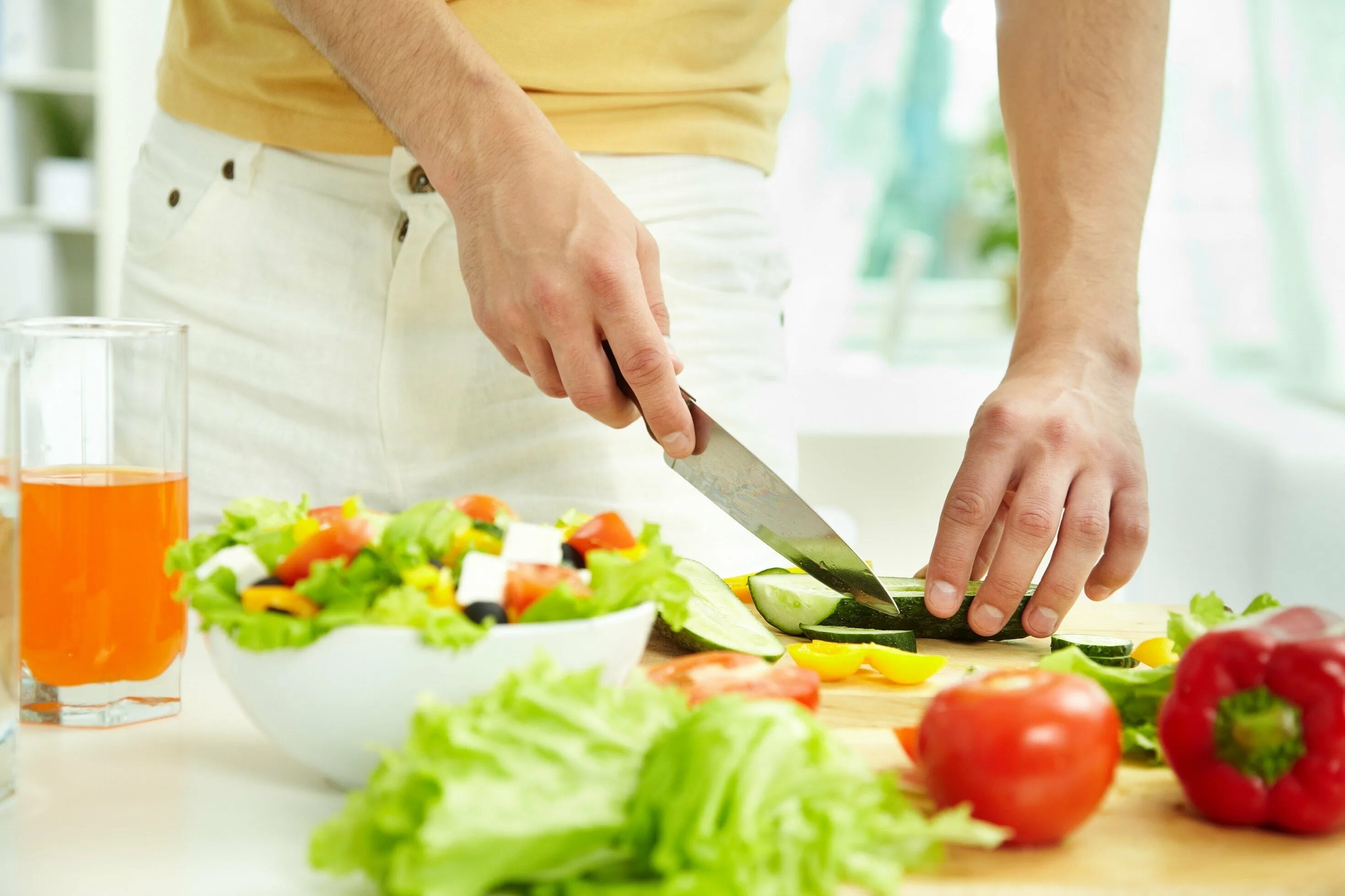 Нарезание овощей. Подготовка продуктов. Правильное приготовление пищи. Нарезанные овощи. Нож режет овощи