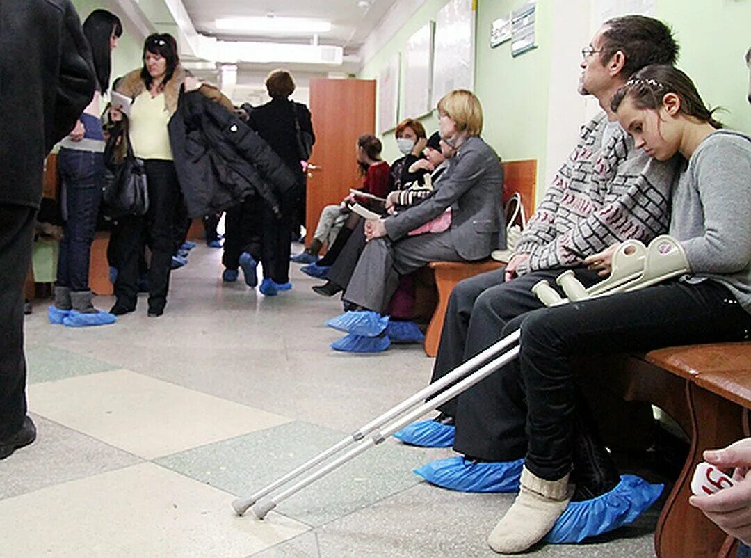 Встать в очередь к врачу. Очередь в травмпункте. очередь в больнице. люди в очереди в поликлинике. люди сидят в очереди.