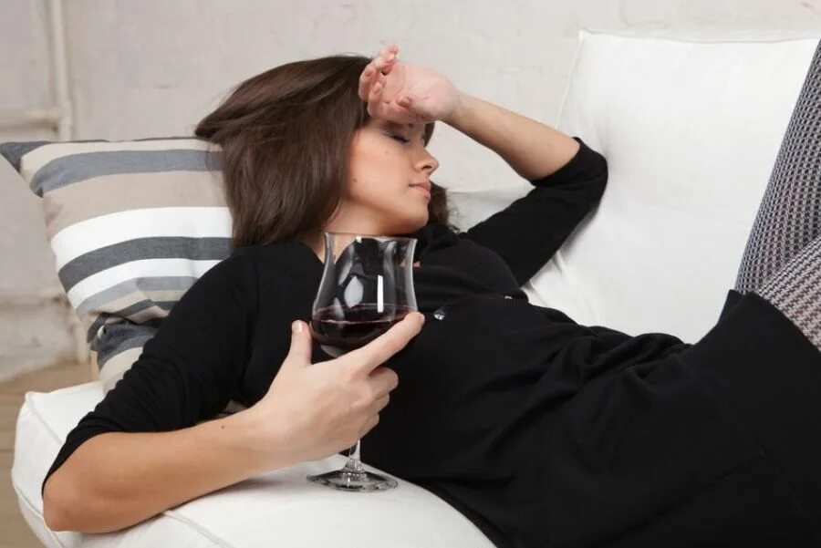 Почему жена пьет. Женщина и алкоголь. Девушка на диване с бокалом вина. Девушка пьет вино на диване. Девушка с алкоголем.