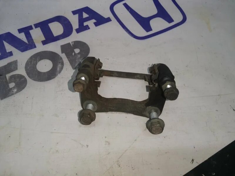 Honda jazz 2002-2007 скоба суппорта задний тормозной. Скоба тормозного суппорта хонда аккорд 8. Скоба суппорта хонда аккорд. Скоба 131-4501276. Скоба заднего суппорта honda crv 2004.