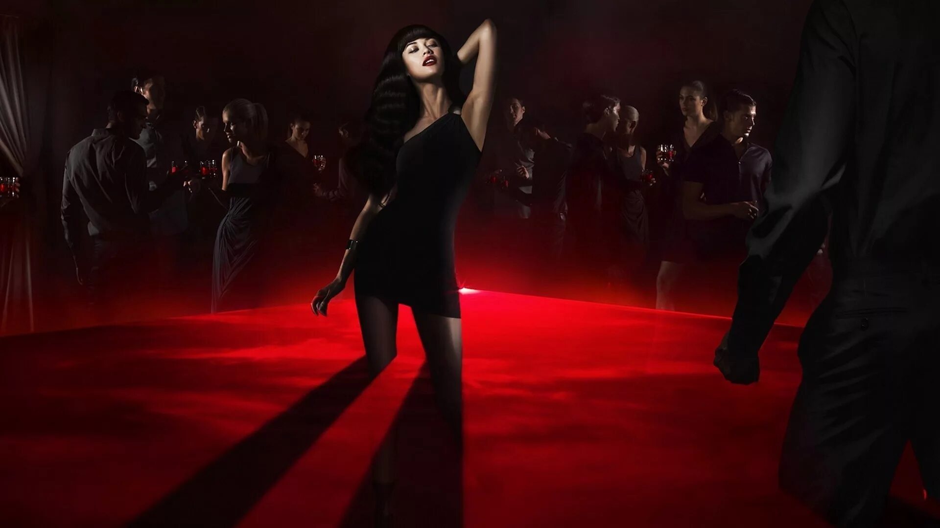Брюнетка в темноте. Девушка танцует. Брюнетка в черном платье. Девушка танцует в клубе.