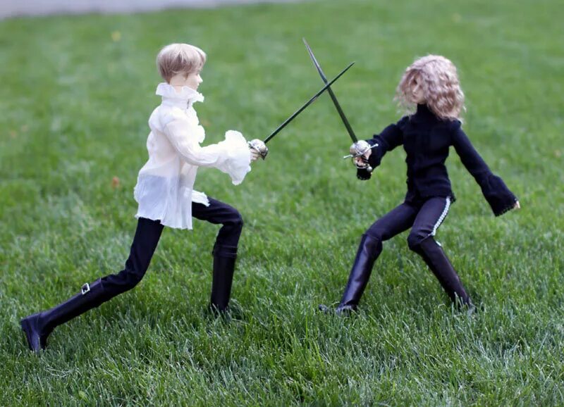 Сражаются на дуэли. Дети сражаются на мечах. Девушка со шпагой. Дуэль на рапирах. Фотосессия со шпагой.