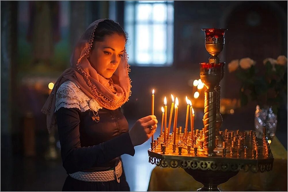 Ставит свечку девушке