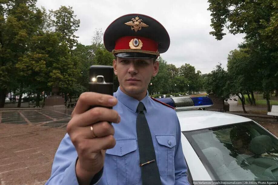 Полицейский фотографирует. Полицейский с телефоном. Милиционер с телефоном. Телефон полиции. Милиционер вася