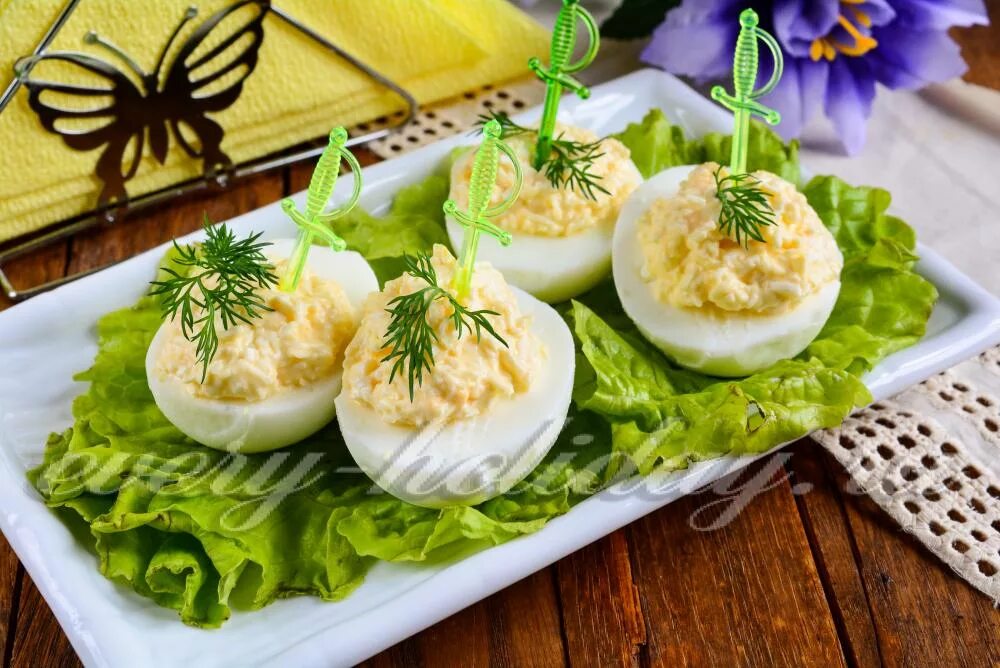 закуска яйца фаршированные. желток с чесноком майонезом. закуска с сыром и чесноком. яйца фаршированные с чесноком и майонезом с желтком. фаршированные яйца с сыром.