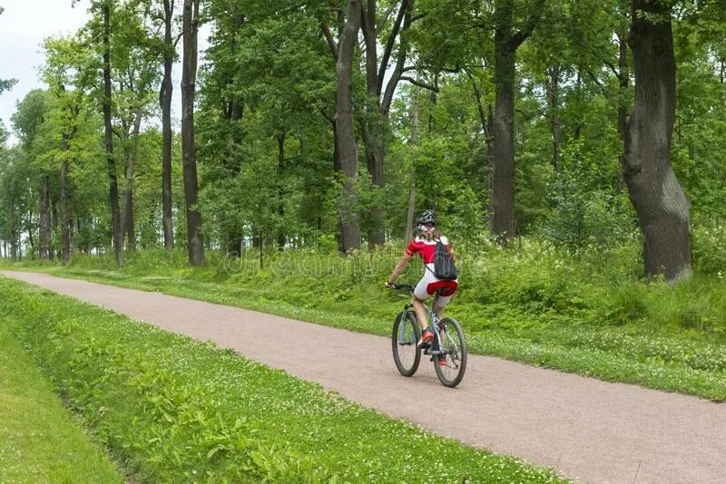 Велосипедист едет по тропинке. Дороги у поля Саратов с велосипидистом. Фото пугачеры Велоспорт в зеленом фоне.