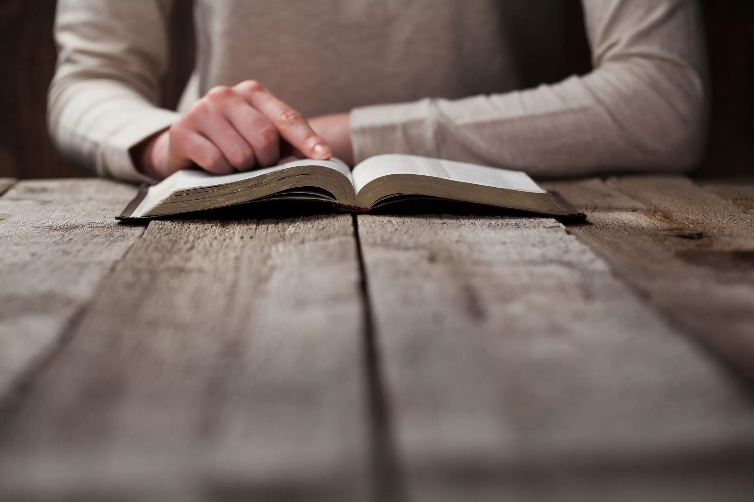 На столе лежит книга которая отражается. Человек с Библией в руках. Библия в руках. Книга в руках. Человек с книгой в руках.