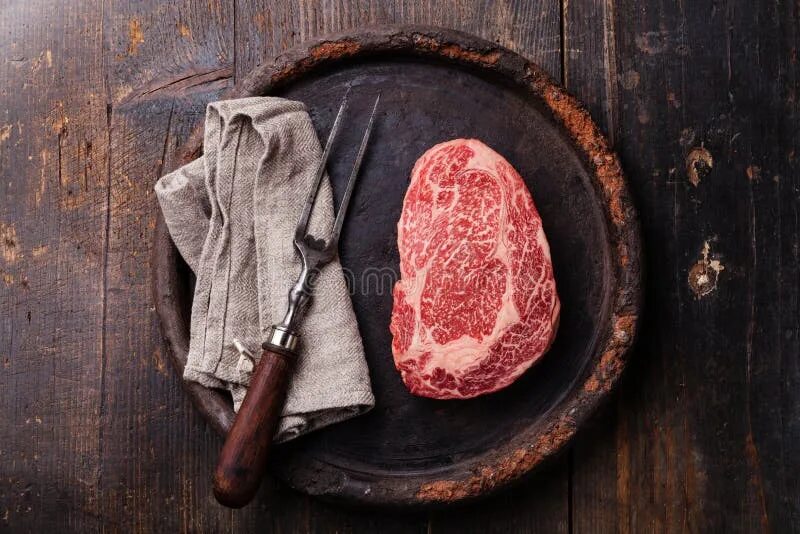 Стейк рибай black angus. Стейк рибай блэк ангус. стейк рибай мраморная говядина. мясо на деревянной доске. стейк на темном фоне.