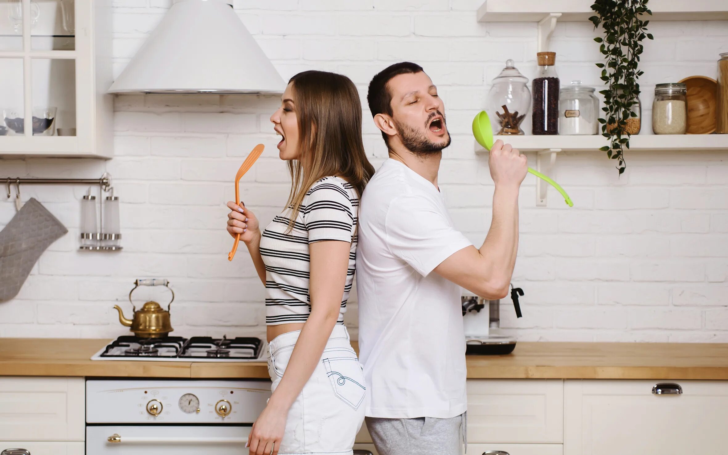 Дает мужу на кухне. Парень на кухне с телефоном. Woman and man at Kitchen.