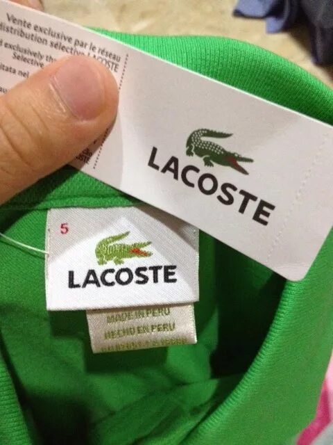 Как отличить lacoste. Lacoste этикетка. Lacoste лейбл. Оригинальная бирка Lacoste. Поло Lacoste оригинал.