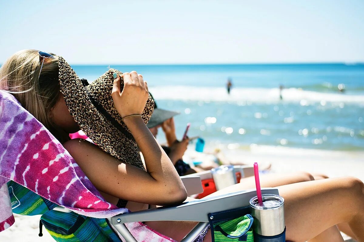 She take a holiday. Лето отпуск. Отдыхающие на пляже. Пляж море люди. Женщины отдыхают на море.