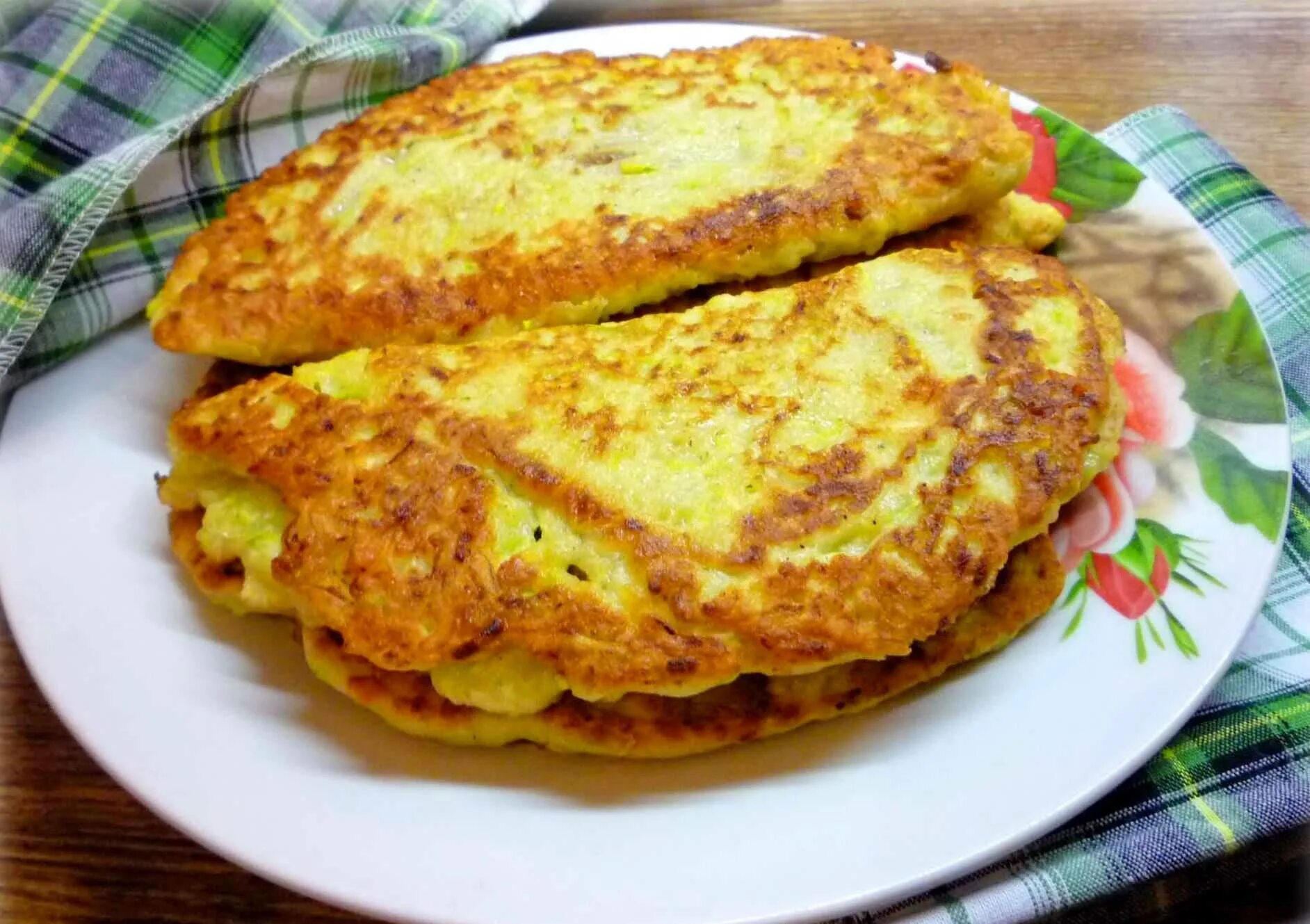 Блин из кабачка на сковороде. Кабачковые чебуреки с фаршем. Блины с зеленью. Блинчики с кабачков. Фото блины из кабачков.