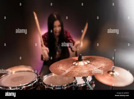 Rock and roll girl playing hard rock music with drums set Stock Photo. 