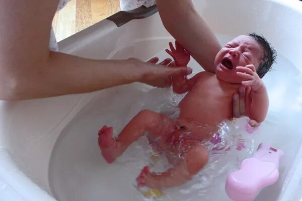 Купание младенца. Ванна для новорожденного. Купание грудничка. Новорожденный плачет при купании. Зачем купаться