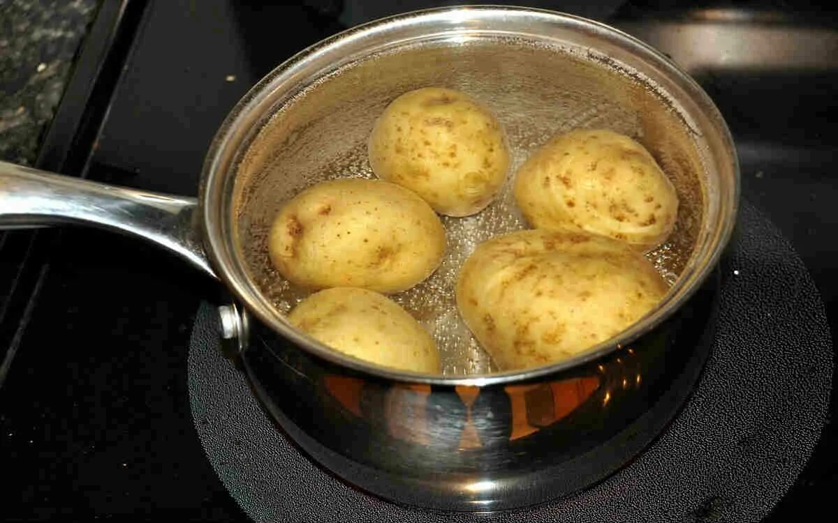 Сколько варить картошку после закипания. Картошка варится. отварить картофель. вареная картошка в мундире. картофель в кастрюле.